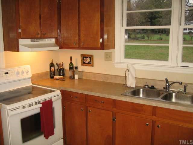 209 Lord Berkley Road Raleigh, NC 27610 - Photo 8 of 12 a kitchen with stainless steel appliances granite countertop a sink a stove and a wooden cabinets