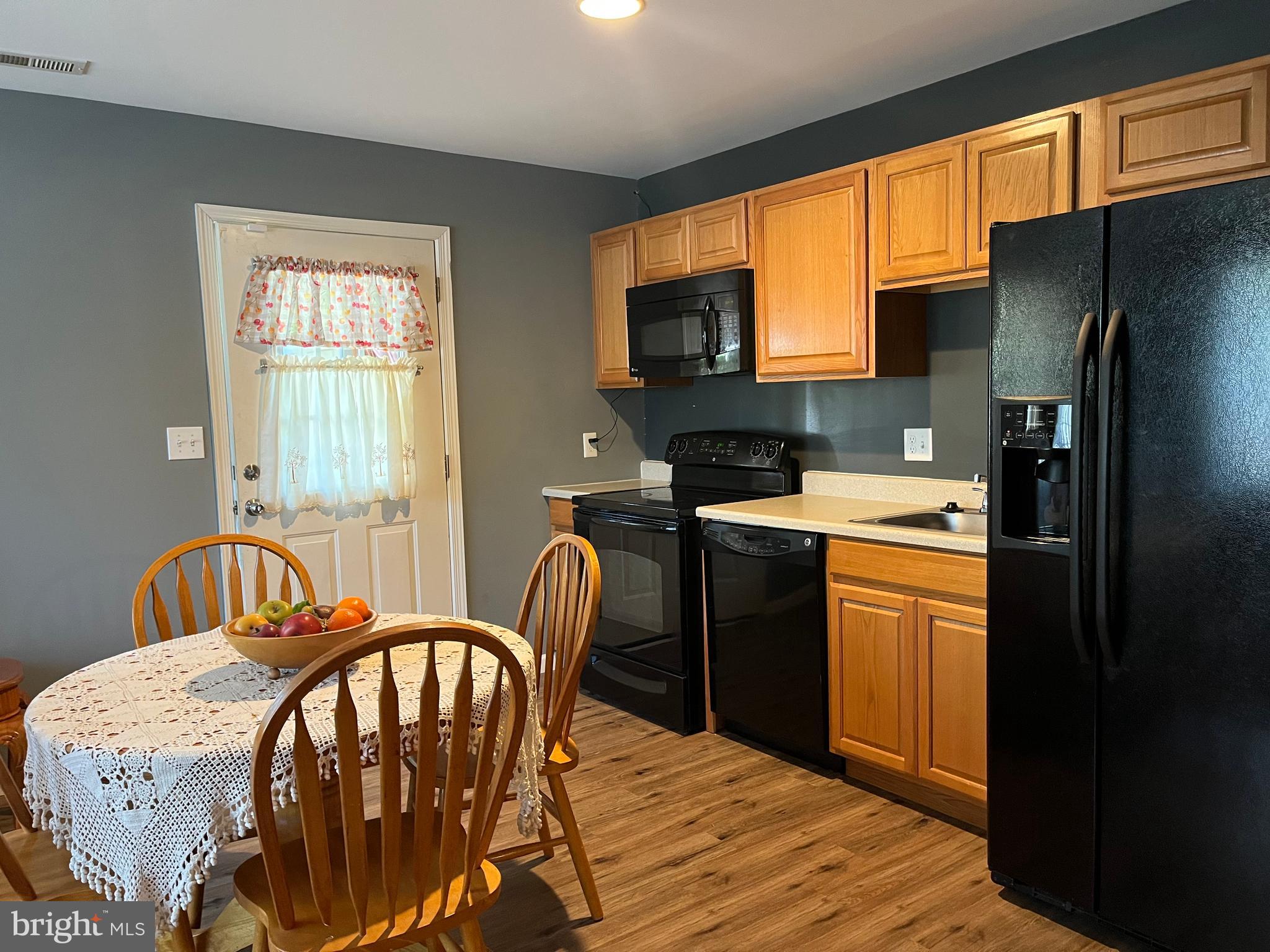 199 Rumbling Rock Road Hedgesville, WV 25427 - Photo 37 of 44 a kitchen that has a table chairs in it and wooden floors