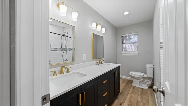 a spacious bathroom with a toilet sink and mirror