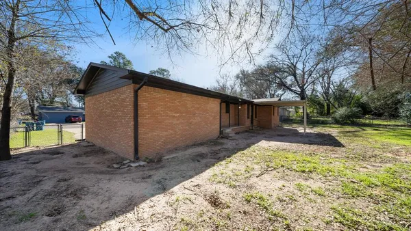 a view of a house with backyard and tree