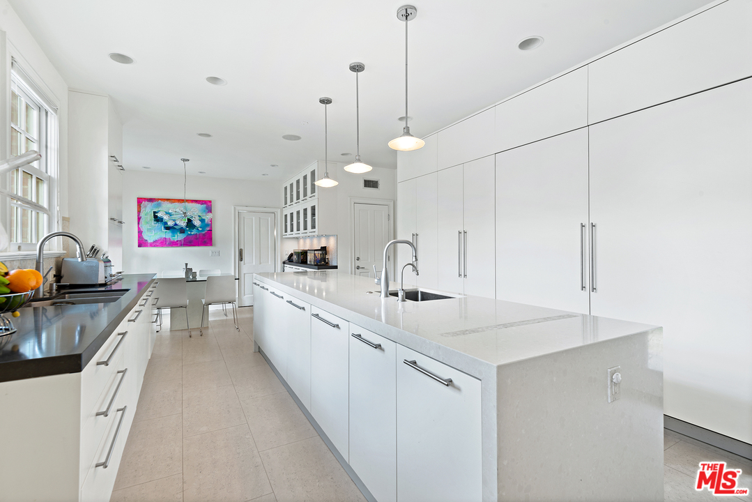 801 Devon Avenue Los Angeles, CA 90024 - Photo 12 of 25 a large kitchen with kitchen island a stove a sink a center island a stove a chimney and a center island
