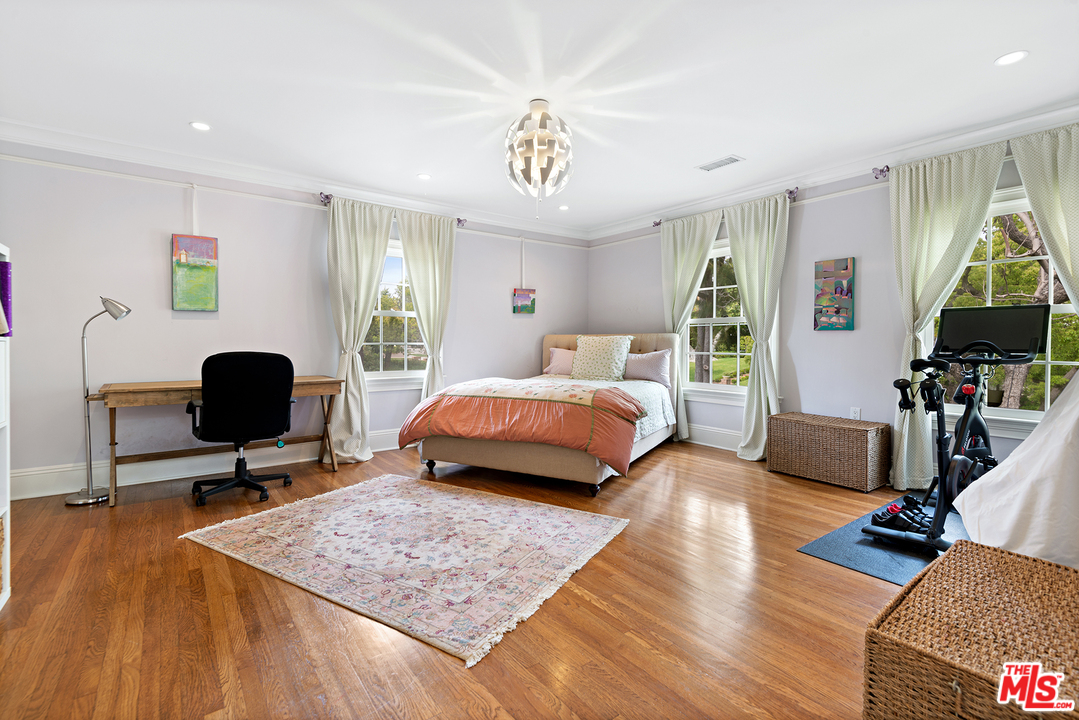 801 Devon Avenue Los Angeles, CA 90024 - Photo 16 of 25 a bedroom with a bed a couch and a chandelier