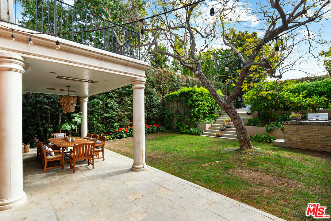 801 Devon Avenue Los Angeles, CA 90024 - Photo 20 of 25 a view of a patio with table and chairs potted plants and a large tree