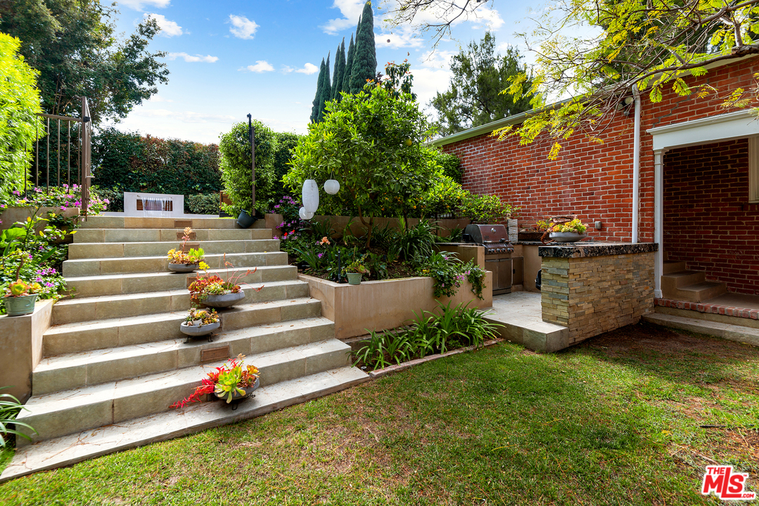 801 Devon Avenue Los Angeles, CA 90024 - Photo 23 of 25 a view of a garden with plants and a bench