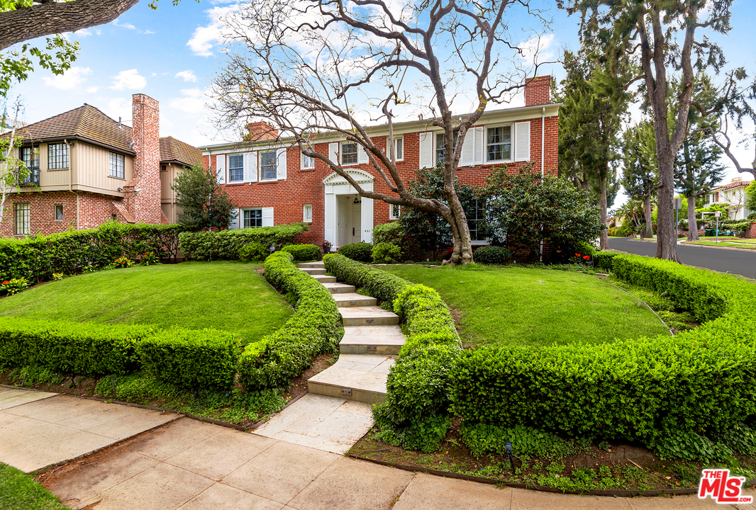 801 Devon Avenue Los Angeles, CA 90024 - Photo 4 of 25 a view of a white house next to a yard with big trees