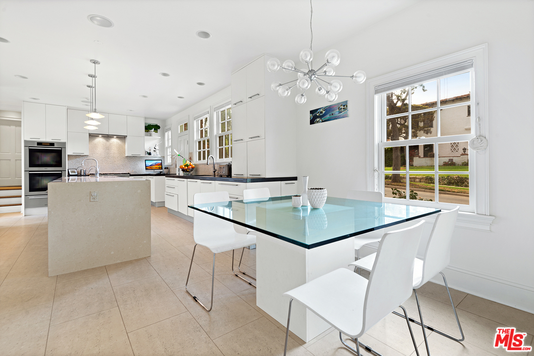 801 Devon Avenue Los Angeles, CA 90024 - Photo 10 of 25 a kitchen with stainless steel appliances kitchen island granite countertop a table chairs and a refrigerator