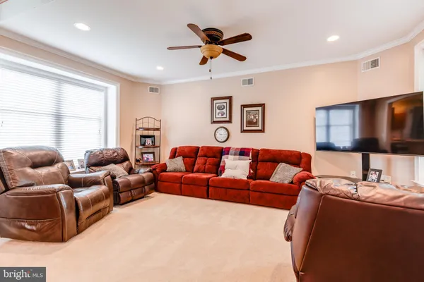 a living room with furniture ceiling fan and a window
