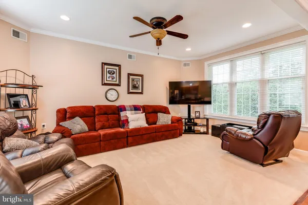 a living room with furniture ceiling fan and a flat screen tv