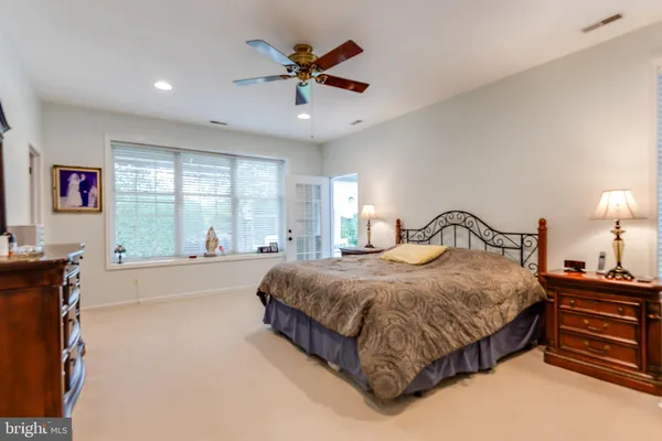a spacious bedroom with a bed and a large window