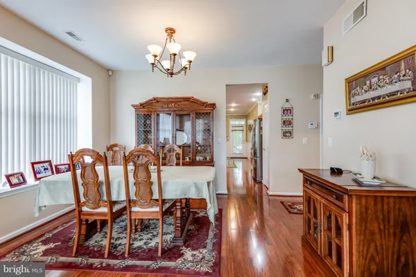 a view of a dining room with furniture a chandelier and wooden floor
