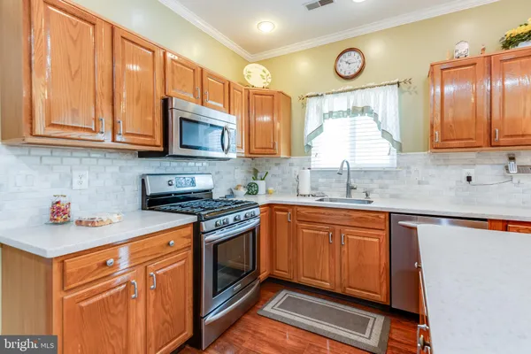 a kitchen with stainless steel appliances granite countertop a sink stove and cabinets