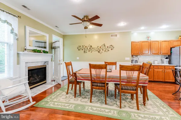 a dining room with furniture a fireplace and wooden floor