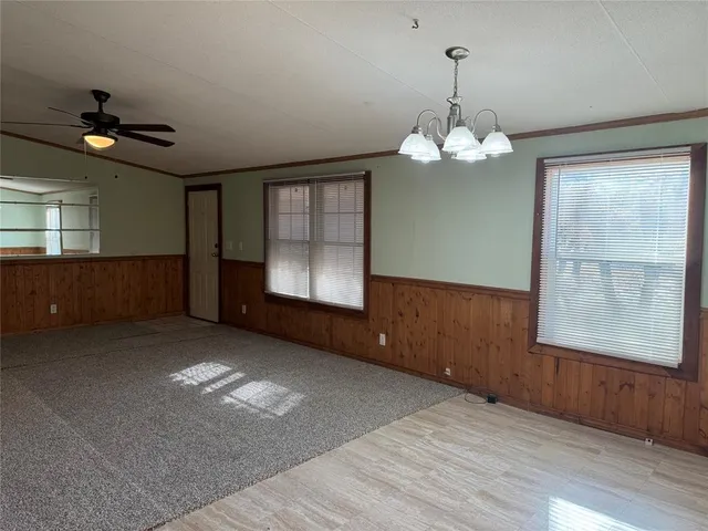 a view of wooden floor chandelier and windows in an empty room