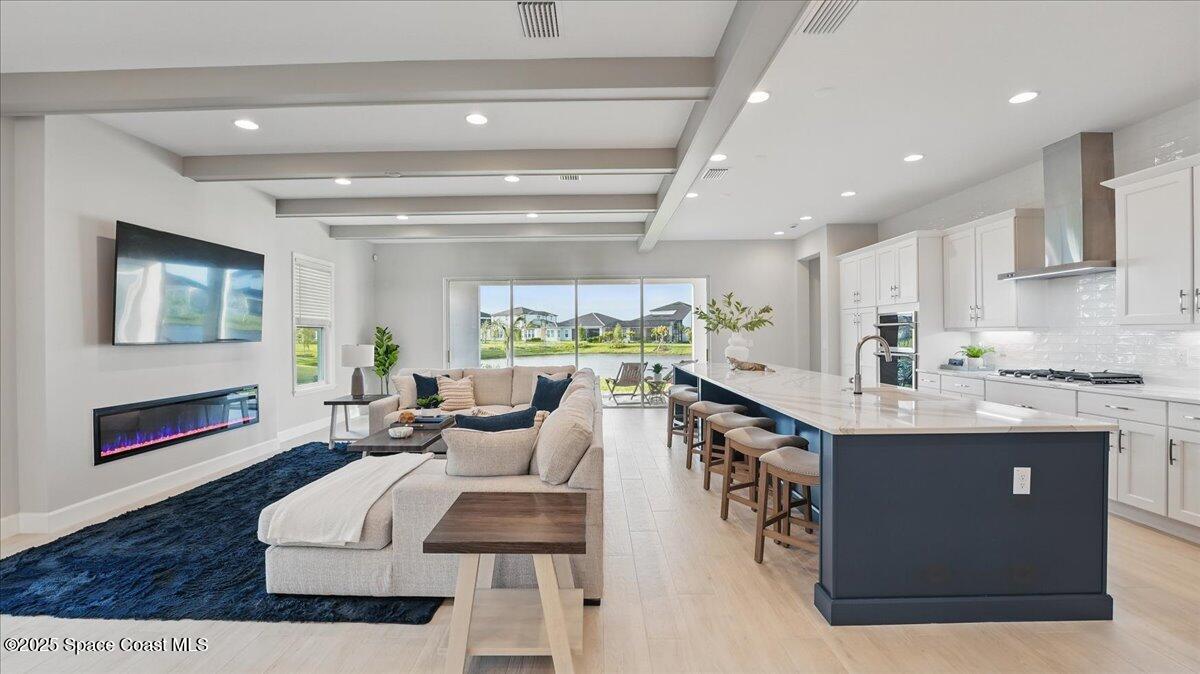 8348 Gullen Drive Melbourne, FL 32940 - Photo 15 of 58 a living room with stainless steel appliances kitchen island granite countertop furniture a rug kitchen view and a chandelier