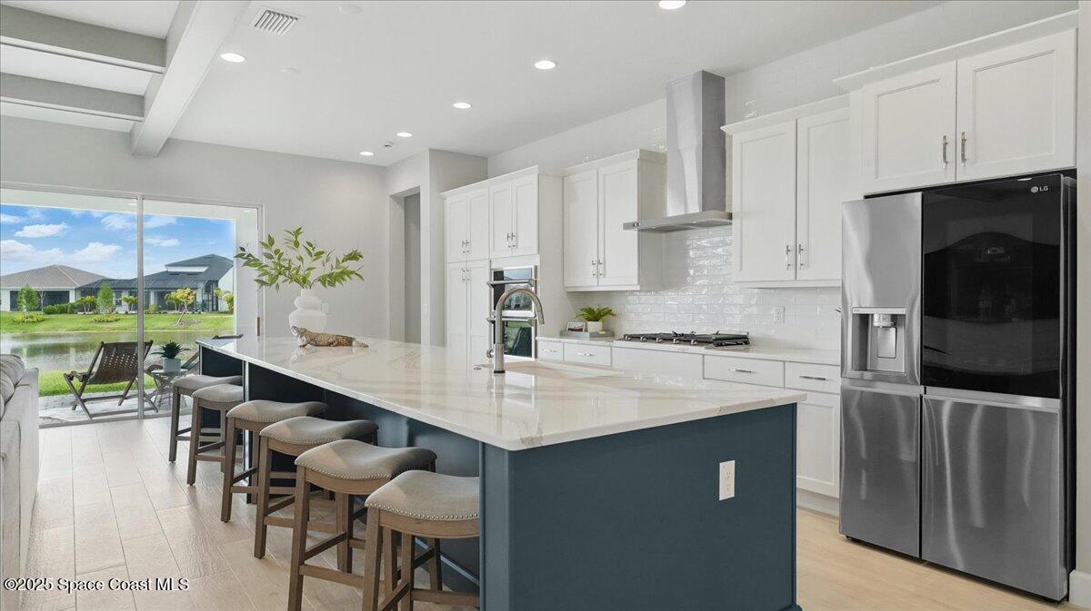 8348 Gullen Drive Melbourne, FL 32940 - Photo 16 of 58 a kitchen with stainless steel appliances kitchen island granite countertop a sink and a refrigerator