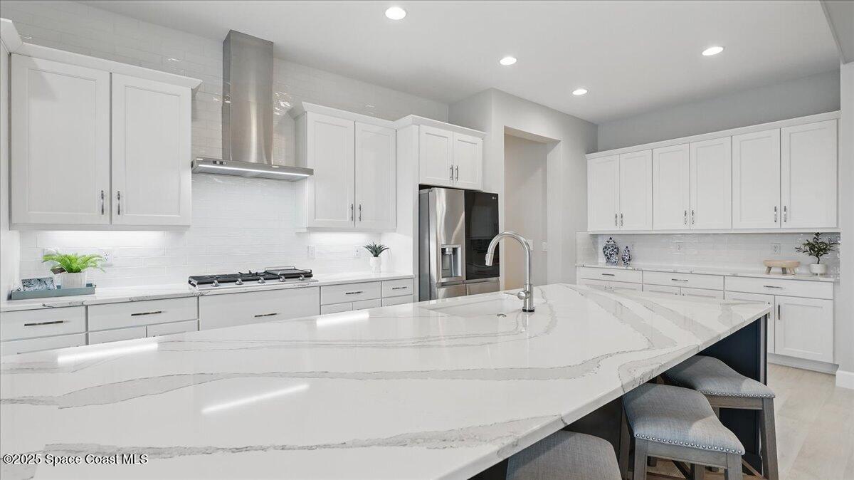 8348 Gullen Drive Melbourne, FL 32940 - Photo 18 of 58 a kitchen with kitchen island a stove a sink and a refrigerator
