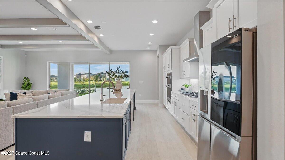8348 Gullen Drive Melbourne, FL 32940 - Photo 19 of 58 a view of a kitchen with kitchen island a counter top space a sink stainless steel appliances and cabinets
