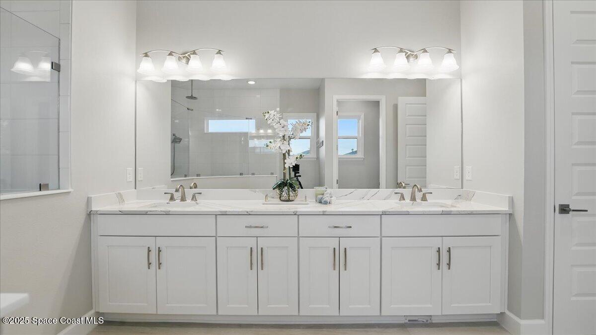 8348 Gullen Drive Melbourne, FL 32940 - Photo 32 of 58 a bathroom with a sink vanity and mirror