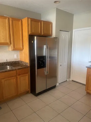 a kitchen with a refrigerator sink and cabinets