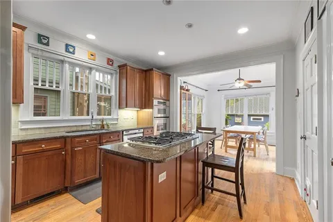 a kitchen with stainless steel appliances kitchen island granite countertop a refrigerator and a stove top oven