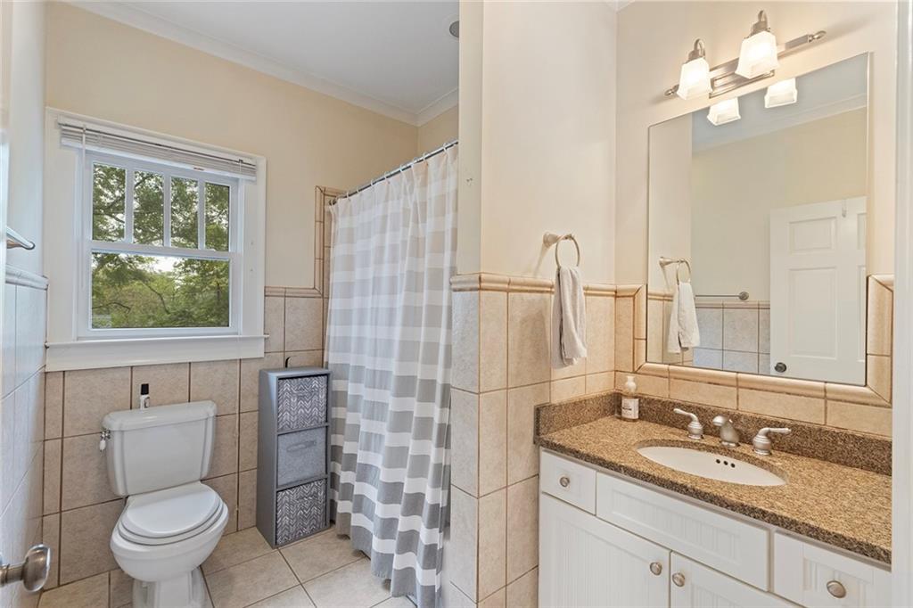 120 Park Place Decatur, GA 30030 - Photo 23 of 35 a bathroom with a granite countertop toilet a sink a mirror a window and vanity