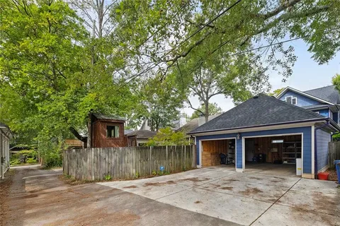 a view of a wooden house with a yard and large trees