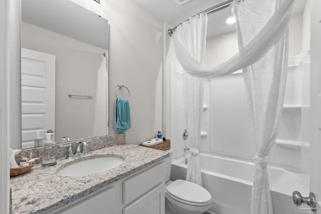a bathroom with a granite countertop sink toilet a mirror and shower