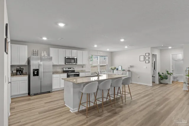 a kitchen with stainless steel appliances kitchen island granite countertop a refrigerator and a stove top oven