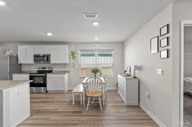 a kitchen with granite countertop cabinets a dining table and chairs