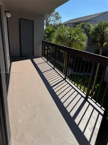 a view of a patio with table and chairs potted plants and large tree