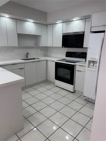 a kitchen with stainless steel appliances a stove a sink and a microwave