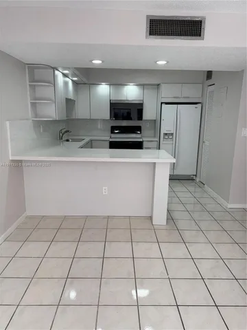 a view of kitchen with stainless steel appliances cabinets and a kitchen counter top