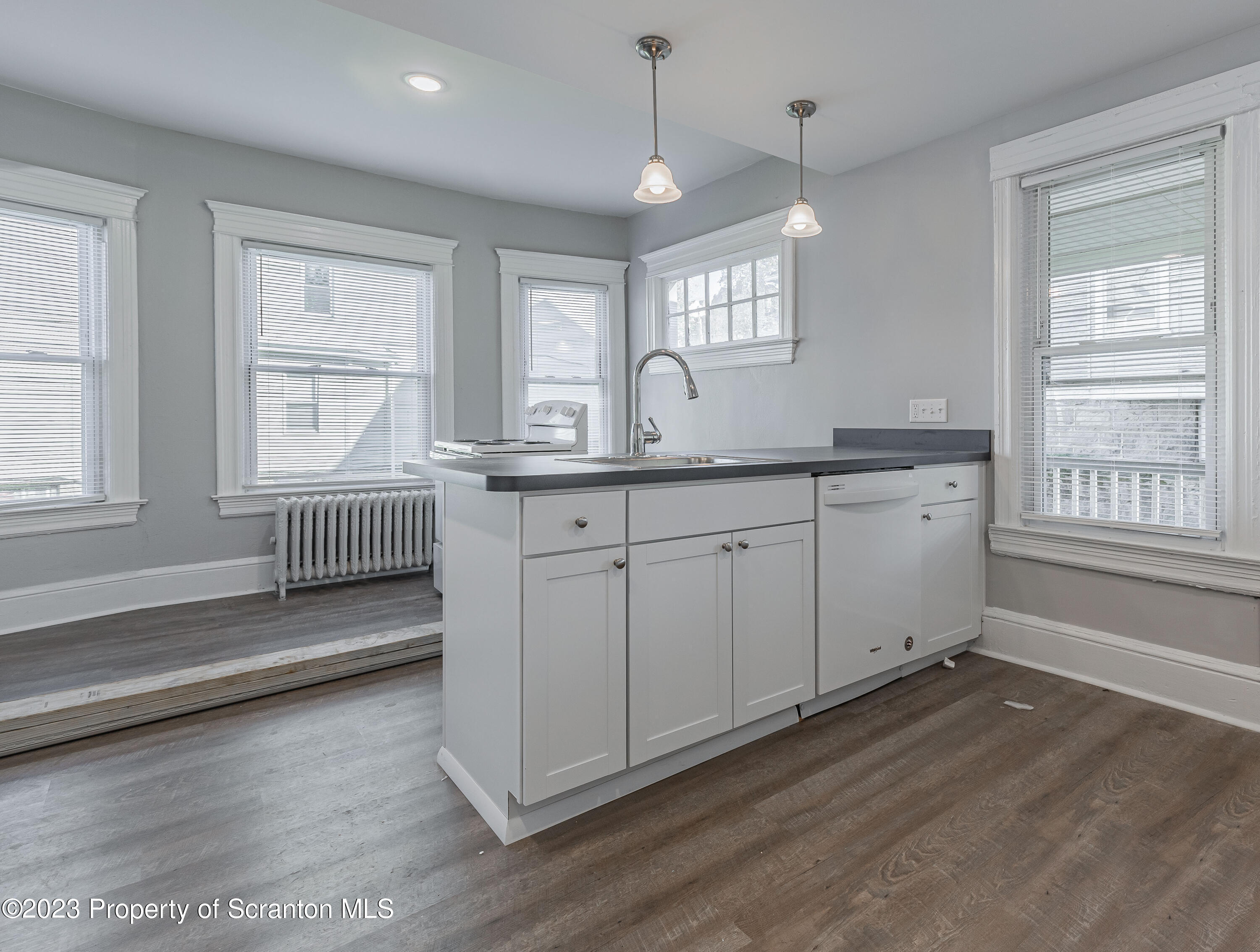 802 Quincy Avenue Scranton, PA 18510 - Photo 4 of 17 a spacious bathroom with a granite countertop sink window and a chandelier