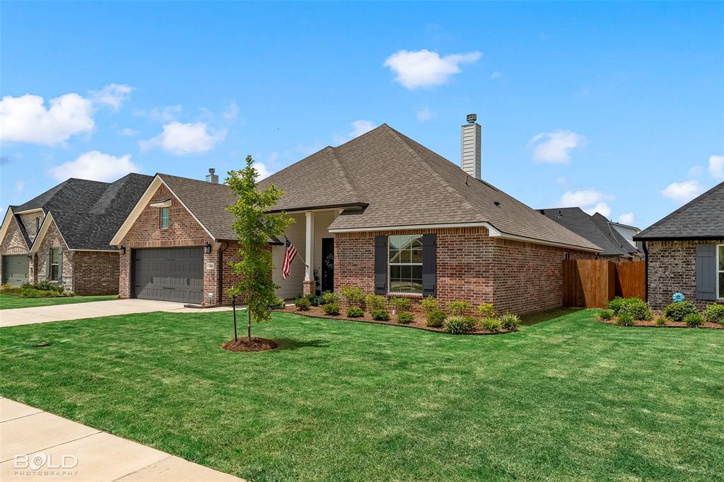 304 Prien Lk Loop Bossier City, LA 71111 - Photo 4 of 39 Brick exterior with dark shutters and an attached garage