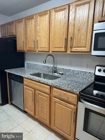 a kitchen with granite countertop white cabinets and stainless steel appliances