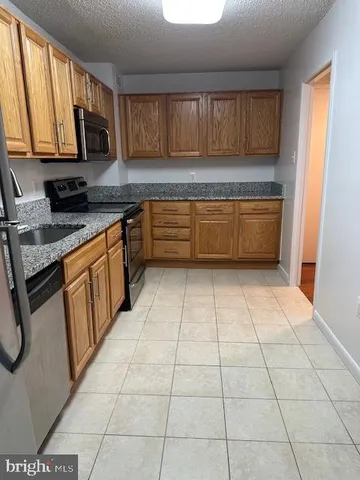 a kitchen with stainless steel appliances a sink a stove a microwave and cabinets