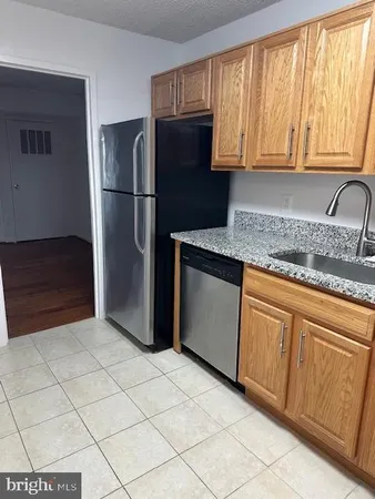 a kitchen with granite countertop a refrigerator and a sink
