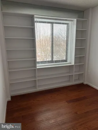 a view of a room with wooden floor and a window