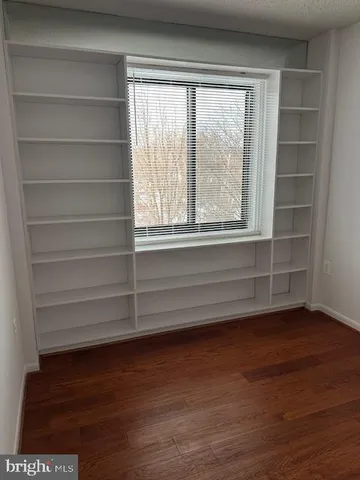 a view of a room with wooden floor and a window