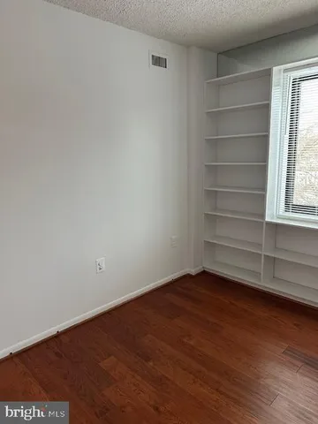 a view of a room with wooden floor and a window