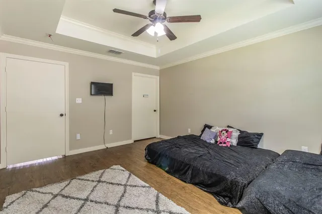 a bedroom with a bed and a chandelier fan