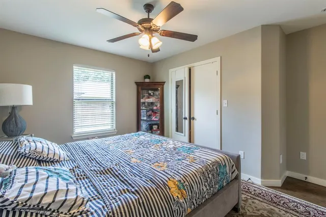 a bedroom with a large bed chandelier and a window