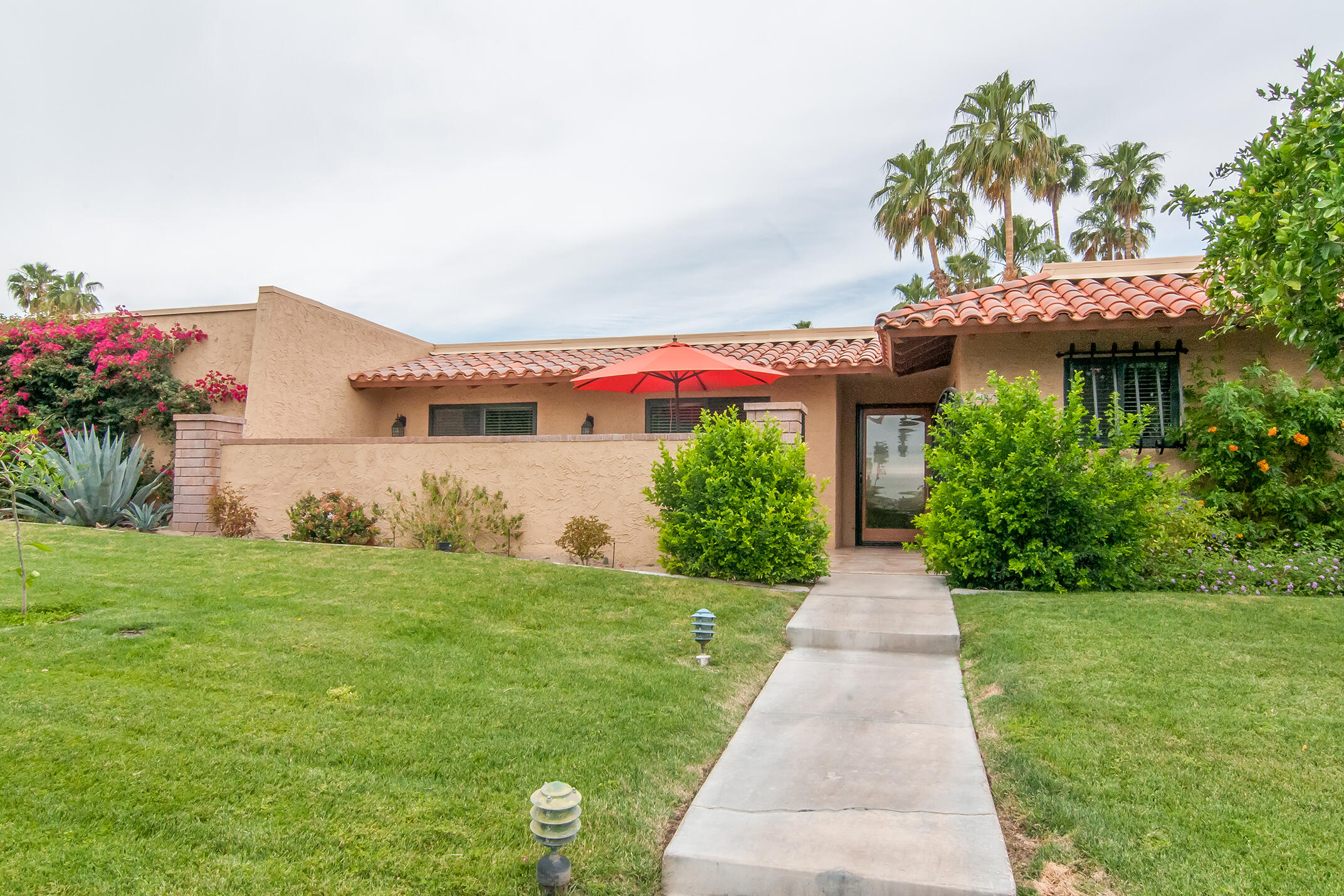 48275 Racquet Lane Palm Desert, CA 92260 - Photo 7 of 29 a front view of a house with a yard and potted plants