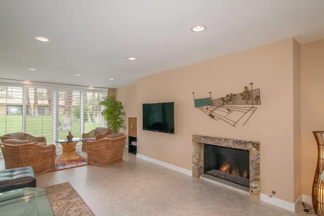 a living room with furniture a flat screen tv and a fireplace