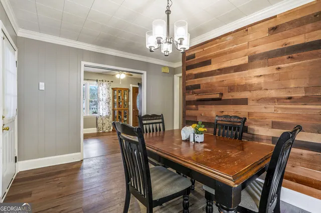 a dining room with furniture a chandelier and wooden floor