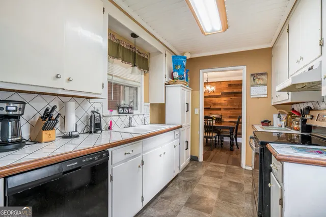 a kitchen with granite countertop a sink stove and cabinets