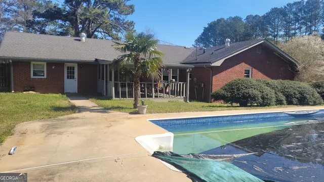 a view of a house with pool and a yard