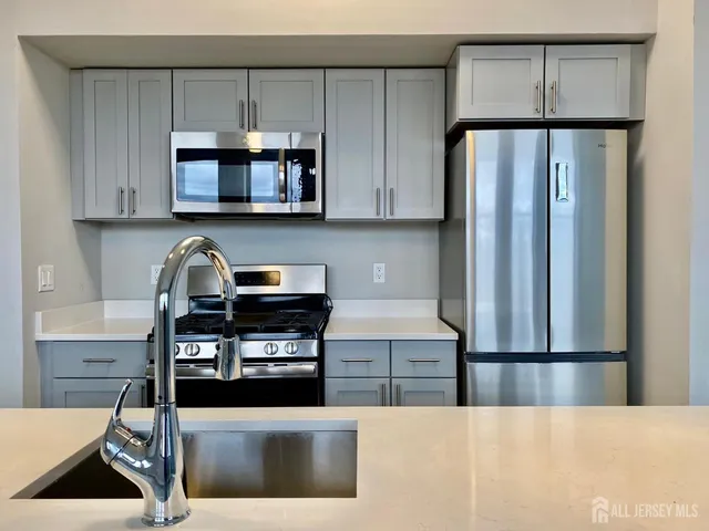 a kitchen with stainless steel appliances a stove a microwave and a refrigerator