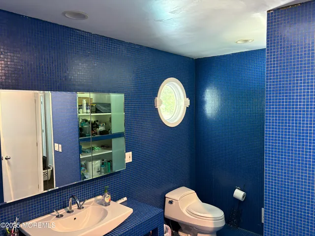 a bathroom with a toilet a sink and mirror