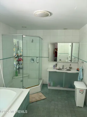 a bathroom with a tub sink mirror and toilet